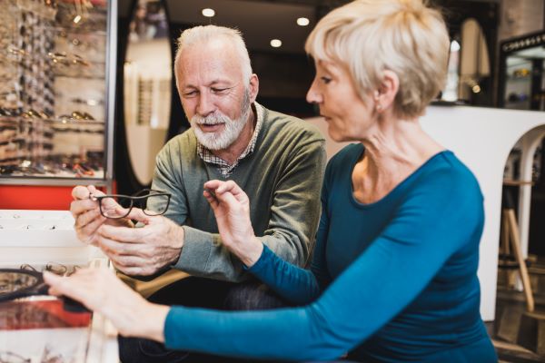 Elderly couple checking out a pair of glasses