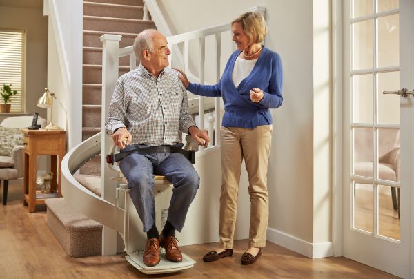 Senior couple riding their acorn stairlift because acorn stairlift is the most reliable stairlift company