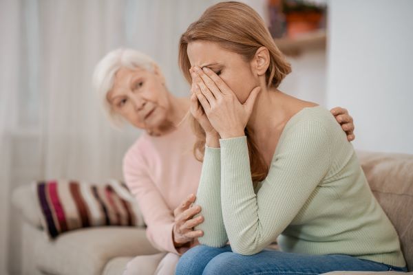 Woman being comforted by a senior 