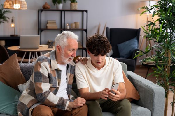 A young adult teaching a senior how to use their phone